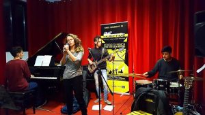 Pianista, bassista e battetista accompagnano un'allieva di canto durante un saggio organizzato dalla scuola Musictime di Milano